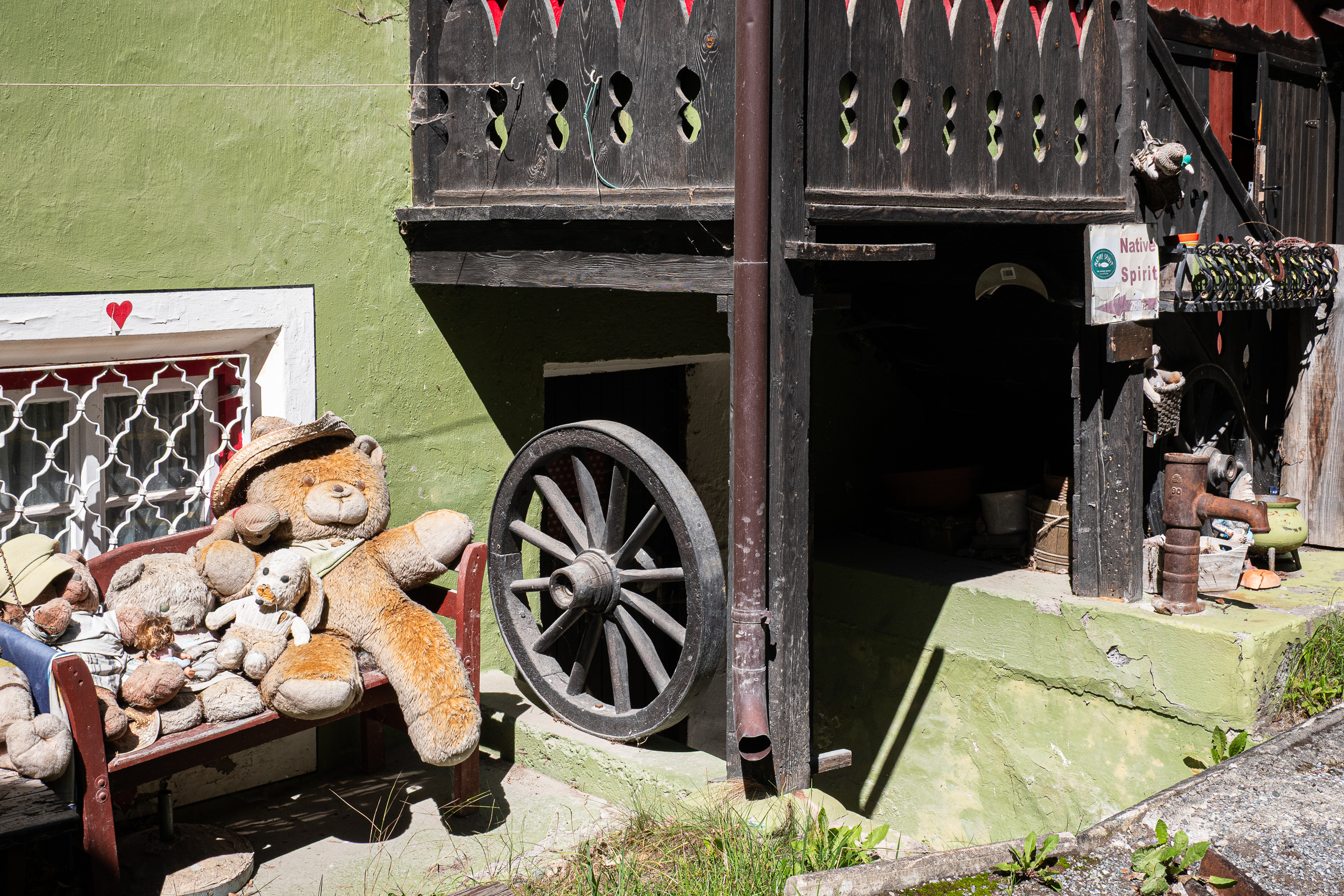 Teddybären auf der Bank vor einem alten Tiroler Haus